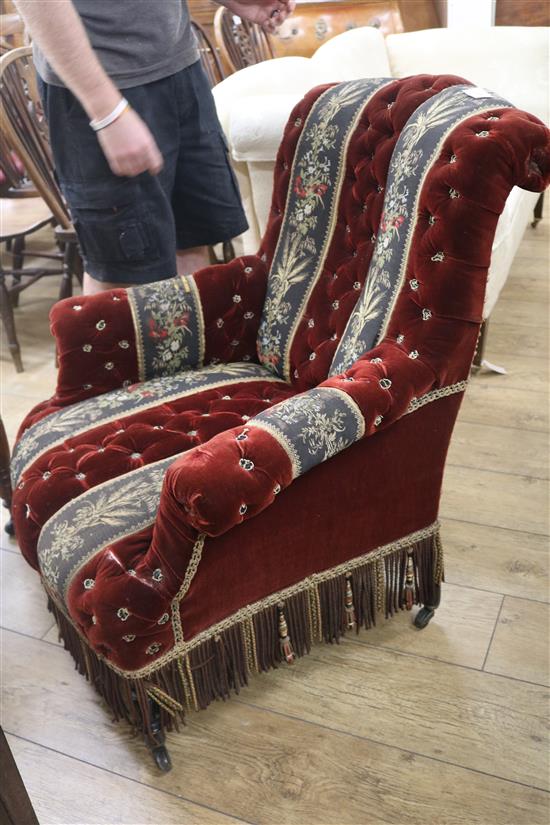 A late Victorian button back ebonised easy armchair